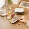 The white portable medicine box is transparent and divided into compartments, containing colored tablets. When the lid is opened by hand, it opens independently and is sealed to prevent moisture details Picture